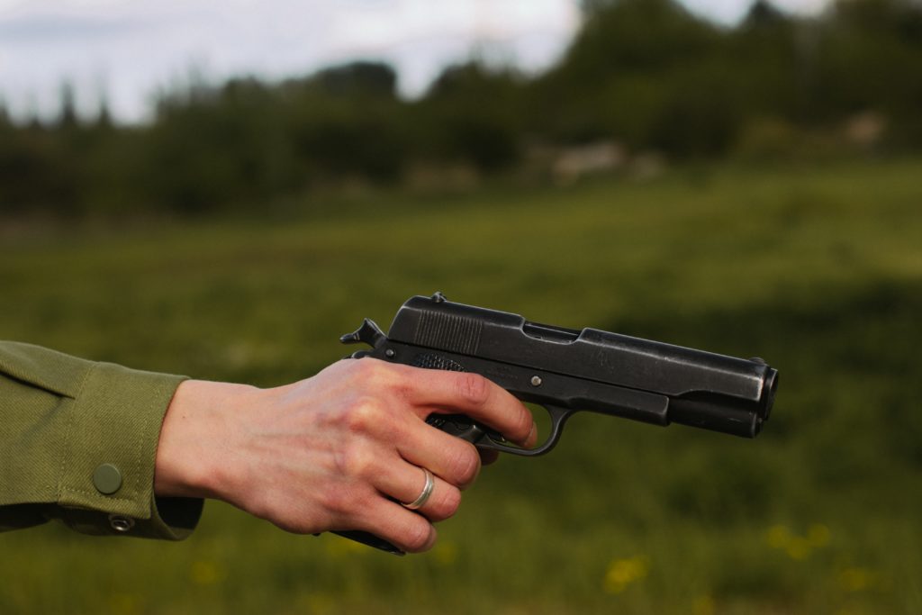 Person Holding Black Semi Automatic Pistol