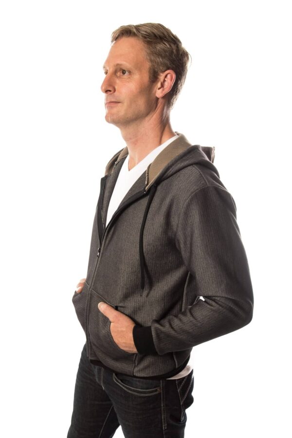 side view of Man wearing SWX stab proof hoodie with two hands in pockets