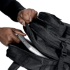 Man pulling a laptop inside a black Ultimate Assault Pack