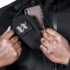Man wearing black Ultimate Assault Pack and taking out a mobile phone front view