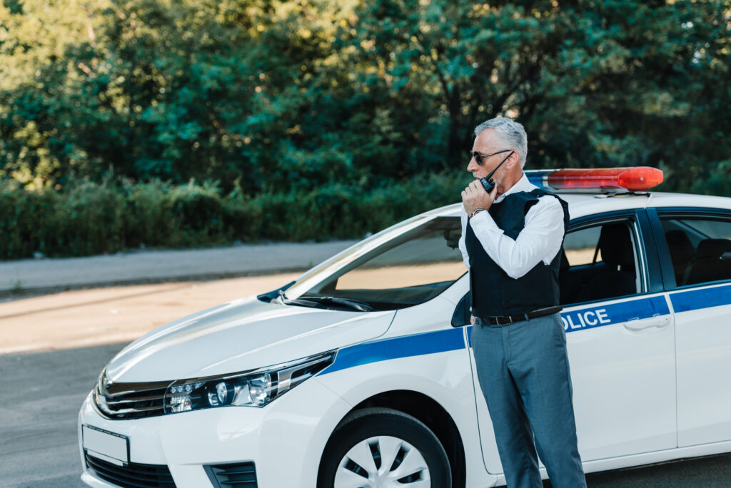 Middle aged policeman in bulletproof vest talking on radio